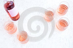 Rose Wine Bottle and Filled Glasses on White