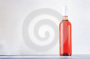 Rose wine bottle on the gray table. Pink rosado, rosato or blush wine tasting in wineshop, bar concept. Copy Space photo