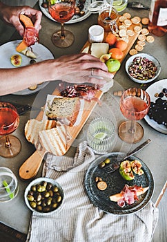 Rose wine, cheese, charcuterie, snacks and mans hands holding food