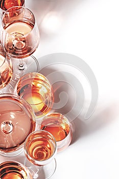 Rose wine of different shades in glasses on white background. Rosado, rosato or blush wines tasting photo