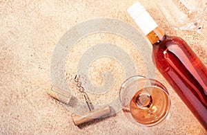 Rose wine glass with bottle on the beige table. Rosado, rosato or blush wine tasting in wineshop, bar concept. Copy Space, top