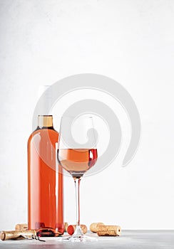 Rose wine glass and bottle on the gray table background on wine tasting photo