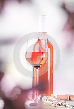 Rose wine glass with bottle on the gray table. Pink rosado, rosato or blush wine tasting in wineshop, bar concept. Copy Space photo