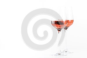 Rose wine glass with bottle on the white table. Rosado, rosato or blush wine tasting in wineshop, bar concept. Copy Space