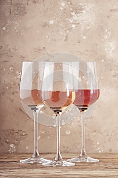 Rose wine glasses on the beige table. Rosado, rosato or blush wine tasting concept, negative space photo