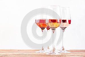 Rose wine glasses set on wine tasting. Different varieties, colors and shades of pink wines on white background photo