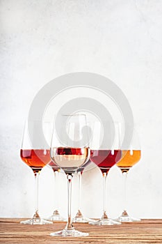 Rose wine glasses set on wine tasting. Different varieties, colors and shades of pink wines on white background photo