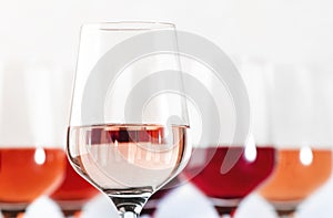 Rose wine glasses set on wine tasting. Tasting different varieties, colors and shades of pink wine concept. White background photo