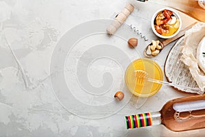 Rose wine pink wine bottle with appetizer set for romantic dinner on light gray stone background. Mediterranean food