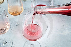 Rose wine poured into a glass at a tasting at a winery, with copy space