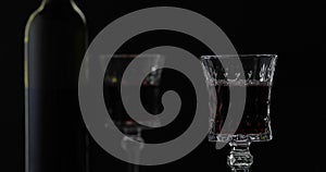 Rose wine. Red wine in wine glass over black background. Silhouette