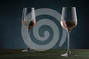 Rose wine from the zinfandel variety in wine glass on dark background, copy space photo