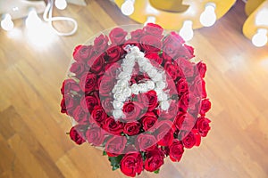 Rose wooden background. Roses flower texture. Red rose. Bouquet of red roses. copyspace . The letter A is written with white