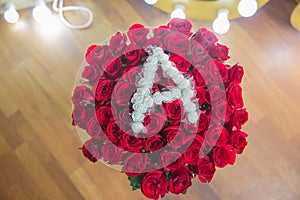 Rose wooden background. Roses flower texture. Red rose. Bouquet of red roses. copyspace . The letter A is written with white