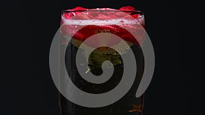 Rosebud at the bottom of the glass, the waiter pours champagne into it. Black background