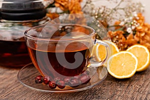 Rosehip tea in a clear teapot and cup. Autumn vitamins for health