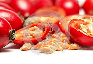 Rosehips Rosa Canina fruits ,cut in half seeds visible macro closeup detail, isolated on white background