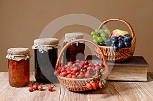 Rosehips in wicker baskets, fruit and jam