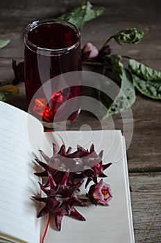 Roselle drink on Wood desk with a books note and repice