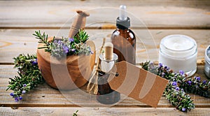 Rosemary aromatherapy. Essential oil and cosmetics, blank tag, banner. Wooden table background