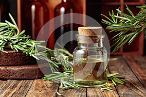 Rosemary essential oil or infusion on an old wooden table