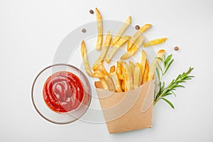 Rosemary french fries and sauce in a paper cup on a white background