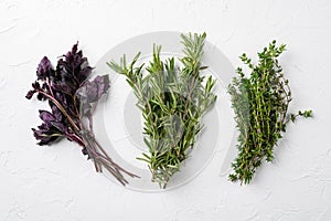 Rosemary, thyme, basil mixed fresh herbs, on white stone table background, top view flat lay, with copy space for text