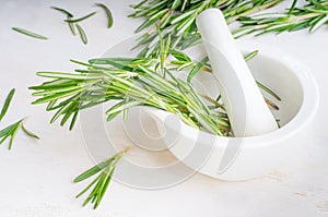 Rosemary twigs in the pounder on white wooden table