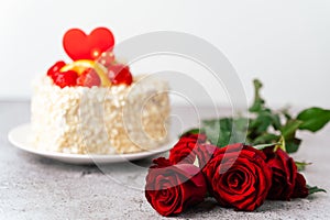 Roses flowers and Valentine's Day cake with heart shape and fruits, strawberries. Birthday Cake for celebration
