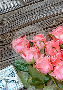 Roses and gift box over old wood background