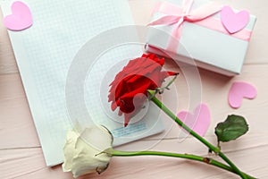 Roses and gift box on wooden background. Copy space for the text. Valentine`s Day or Wedding greeting card.