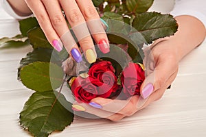 Roses in hands with perfect manicure.