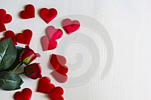 Roses and hearts on white wooden background