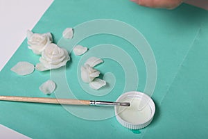 Roses with petals made of white polymer clay. Glue and brush. Crafts from polymer clay