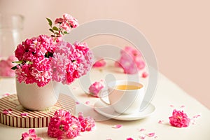 roses and tea cup served for breakfast on plain background, copy space for text, valentine's day, wedding or anniversary