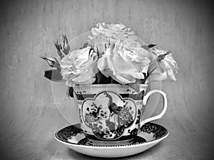 Roses in teacup. Retro monochrome concept.