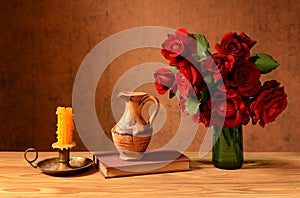 Roses in a vase, books and candles