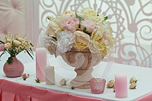 Roses in a vase and candles on the table