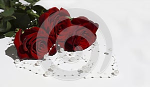 Roses on a white background, pearl necklace, copyspase