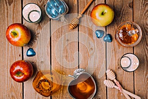 Rosh Hashana holiday background with honey, apples and candles on wooden table. View from above.
