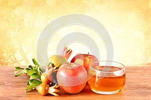 Rosh hashanah concept - apple honey and pomegranate over wooden table