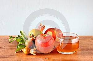 Rosh hashanah concept - apple honey and pomegranate over wooden table.