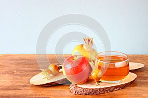 Rosh hashanah concept - apple honey and pomegranate over wooden table