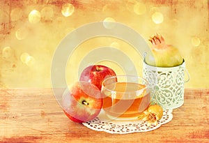 Rosh hashanah concept - apple honey and pomegranate over wooden table