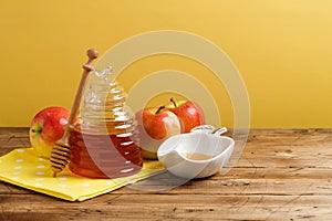 Rosh hashanah holiday Jewish new year celebration concept. Honey and apples over yellow background