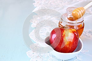 Rosh hashanah (jewesh holiday) concept - honey and apple over wooden table. traditional holiday symbols.