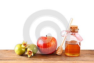 Rosh hashanah (jewesh holiday) concept - honey, apple and pomegranate over wooden table. traditional holiday symbols.