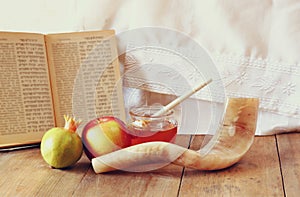 Rosh hashanah (jewesh holiday) concept - honey, apple and pomegranate over wooden table. traditional holiday symbols.