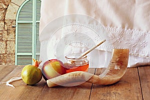 Rosh hashanah (jewesh holiday) concept - honey, apple and pomegranate over wooden table. traditional holiday symbols.