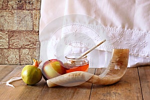 Rosh hashanah (jewesh holiday) concept - honey, apple and pomegranate over wooden table. traditional holiday symbols.